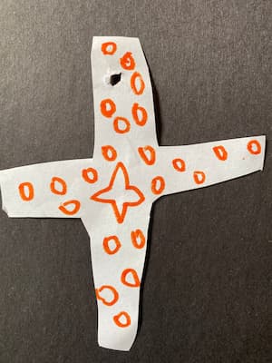 Child's drawing of a swiss cross covered in stars